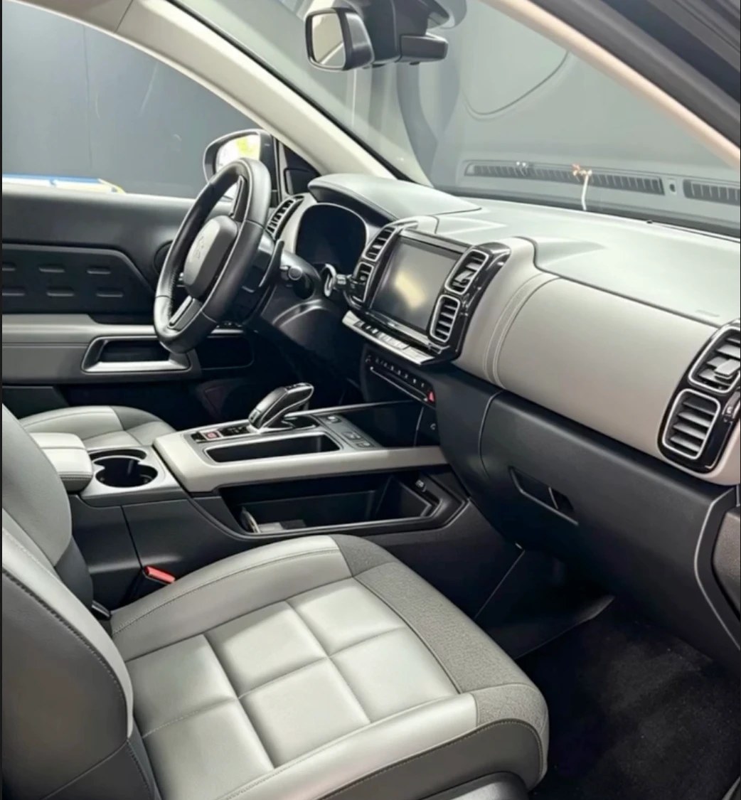 Habitacle gris clair d'un SUV familial après nettoyage : sièges, console et tapis propres